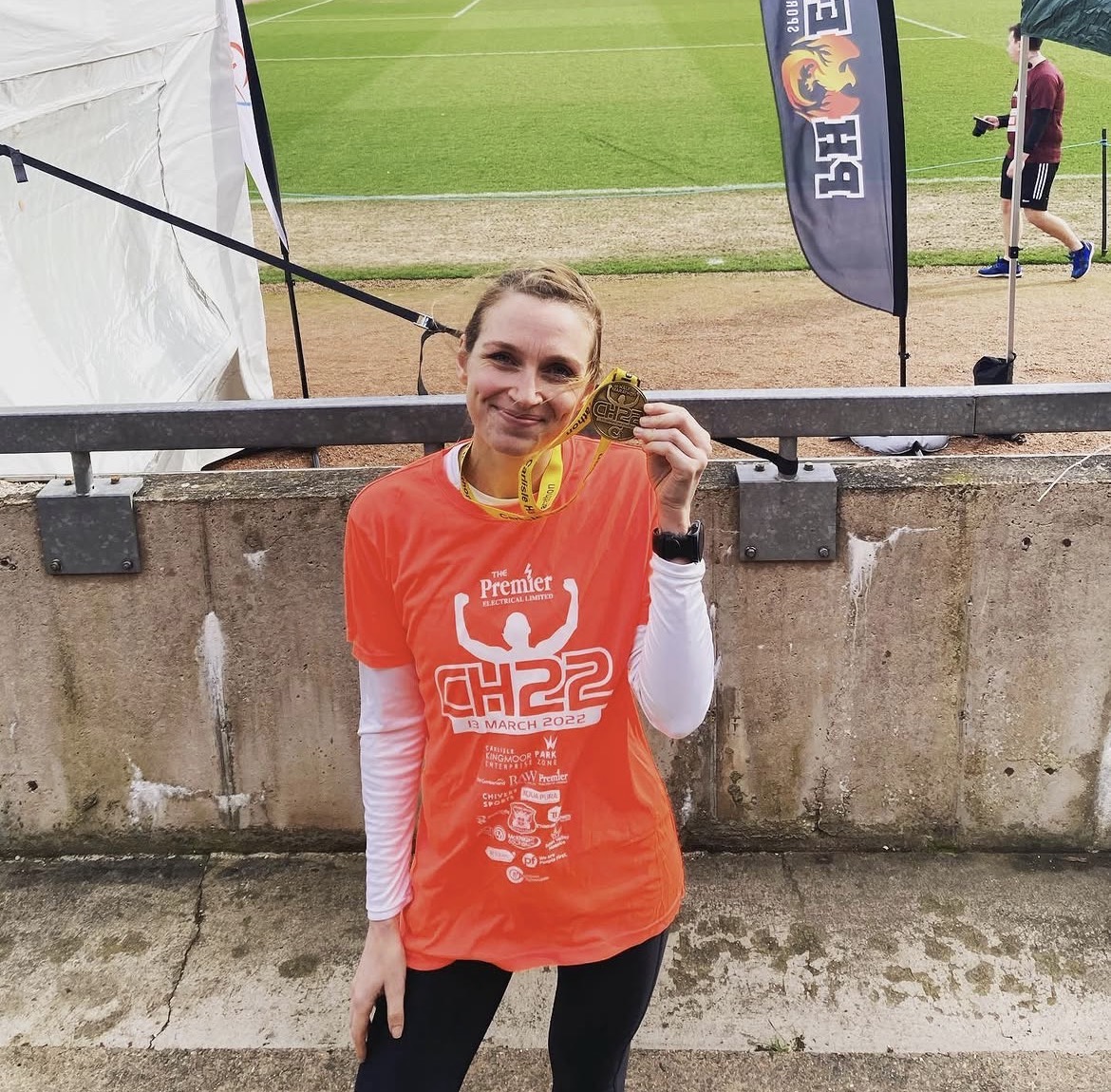 Sports nutritionist at end of half marathon with medal.